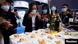 资料照片:在上海参观中国国际进口博览会上的观展者给澳大利亚龙虾拍照。(2020年11月6日)