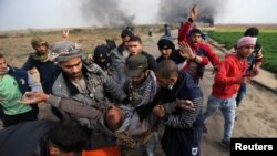 在加沙地带南部与以色列交界处,一名受伤的巴勒斯坦示威者被抬走。(2017年12月29日)