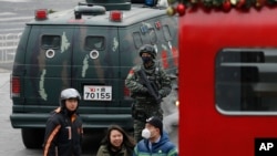 中国武警2015年12月27日在北京三里屯巡逻,可见行人经过警车。