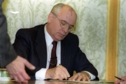 1991年12月25日,苏联总统米哈伊尔·戈尔巴乔夫 (Mikhail Gorbachev) 在国家电视台的现场讲话前几分钟签署辞呈。次日苏联宣告解体。(路透社图片)