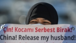 一名维吾尔妇女在中国驻伊斯坦布尔领事馆附近举牌抗议,要求中国政府释放其丈夫。(2021年2月22日)