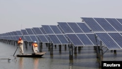 资料照片:中国江苏省连云港市的工人在检查太阳能电池板。(2016 年 3 月16日)