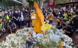 反送中运动首位牺牲性命的抗争者梁凌杰逝世一周年,网民在他堕下身亡的地点设置祭坛,挂上他死前穿着的黄色雨衣,供市民献花。 (美国之音/汤惠芸)