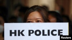 一名香港抗议者手举“香港警察大规模性犯罪”的牌子在中环遮打花园举行示威。(2019年10月11日)