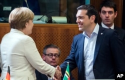 希腊总理齐普拉斯和德国总理默克尔在布鲁塞尔握手(2015年6月10日)