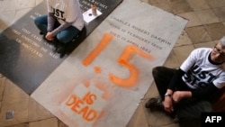 Aktivis Alyson Lee dan Di Bligh dari kelompok Just Stop Oil, Senin (13/1) melukis prasasti di makam naturalis terkenal Charles Darwin di dalam Westminster Abbey, pusat kota London, untuk memprotes kelambanan politik terhadap pemanasan global. (JAMIE LOWE / Just Stop Oil / AFP)