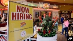 美国劳工部3月10日报告称美国2月份增加了23万5千个就业职位。 佛罗里达州迈阿密的一家餐馆竖立看板招募员工。(档案图片)。