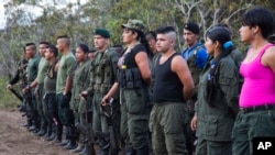 FILE - Rebels of the Revolutionary Armed FOrces of Colombia, FARC, stand on formation at their camp next to the site where is the group is holding it's 10th conference in the Yari Plains, Colombia, Sept. 17, 2016.