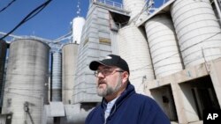 一名美国粮食商人站在俄亥俄州凯勒谷物与饲料公司的粮食大豆储藏罐前接受采访。(2018年4月5日)