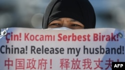一名维吾尔妇女在中国驻伊斯坦布尔领事馆附近举牌抗议,要求中国政府释放其丈夫。(2021年2月22日)
