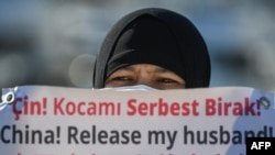 资料照片:一名维吾尔妇女在中国驻伊斯坦布尔领事馆附近举牌抗议,要求中国政府释放其丈夫。(2021年2月22日)