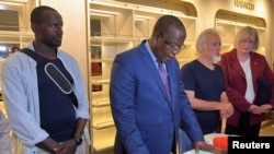 尼日尔内政部长苏莱(中)宣布美国人质伍德克和法国人质杜波依斯(右左)获释。(2023年3月20日)