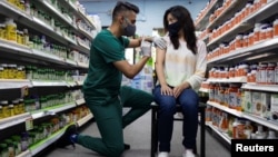 资料照片:一位女士在宾夕法尼亚州施文卡斯维尔的斯基帕克药店接种辉瑞疫苗加强针。 (2021年8月14日)