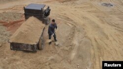 一名中国工人在江西省南城县的稀土矿里工作。(2012年3月14日)