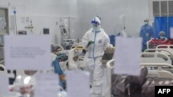 မန္တလေးမြို့ ဧရာဝတီကိုဗစ်စင်တာမှာ ကိုဗစ်လူနာတွေကို ကုသပေးနေတဲ့ ကျန်းမာရေးဝန်ထမ်းများ။ (ဒီဇင်ဘာ ၂၅၊ ၂၀၂၀)