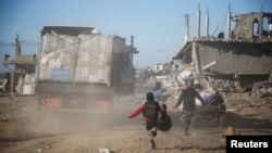 Warga Palestina berlari menuju truk bantuan, menyusul gencatan senjata antara Israel dan Hamas, di Rafah di Jalur Gaza selatan, 20 Januari 2025. (Hatem Khaled/REUTERS)