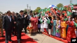 2015年4月20日,中国国家主席习近平在到达巴基斯坦伊斯兰堡努尔·汗空军机场后在巴总统马姆努恩·侯赛因(左)的陪同下向前来迎接的儿童招手(资料图)