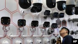 2019年10月29日深圳举行的中国公安博览会上一名男子在仔细观看华为生产的监视摄像头