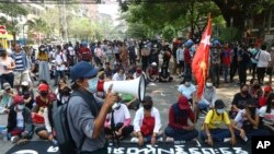 周六(3月27日)缅甸仰光淡汶鎮抗议民众占领一条街道同军警对峙。(美联社照片)