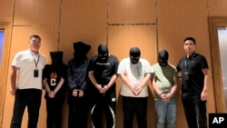 资料照片:2023年8月26日,在缅甸仰光国际机场,缅甸警方将5名电信网络诈骗犯罪嫌疑人移交给中国警方。(Chinese embassy in Myanmar/Xinhua via AP)