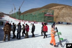 河北省一座滑雪场上的民工、滑雪者和正在建造的滑雪公寓。如果北京获得冬奥主办权,部分比赛将在这里举行(2014年12月6日)