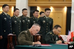美军参联会主席邓福德上将(前左)与中国中央军委联合参谋部参谋长房峰辉在北京签署协议。 (2017年8月15日)
