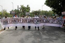 印度示威者在新德里手举写着“我们的国家我们的土地,中国军队滚出去”字样的横幅举行抗议活动。(2020年6月19日)