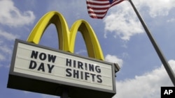 美国俄亥俄州一家麦当劳餐厅旁有美国国旗,餐厅的招牌上写着“现在雇人,白天上班”。