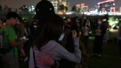 香港民众11月9日晚在添马公园举行集会,悼念不幸去世的香港科技大学学生周梓乐。一对情侣相拥互勉。(美国之音郁岗拍摄)