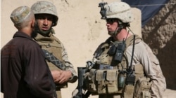 资料照片：一名美国海军陆战队下士在翻译的帮助下在阿富汗某镇与一名村民交谈。(2009年12月6日)
