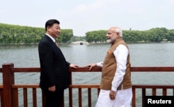 2018年4月28日,中国国家主席习近平和印度总理纳伦德拉·莫迪在中国武汉沿东湖漫步时交谈(印度新闻局通过路透社发布的照片)。