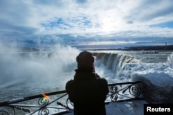 冬日的尼亚加拉大瀑布依然壮观,别有风味。加拿大安大略省的马蹄瀑布附近,有游客照相(2018年1月3日)。