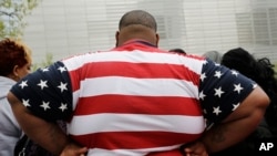 资料照:一位身体过重的男士身穿美国国旗图案的T恤衫参观纽约世贸中心。