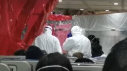 美国撤侨飞机由货机改造而成,没有窗户也没有空乘人员。外交工作人员穿着防护服为乘客发放饮料食品,定时测试体温。(Priscilla Dickey拍摄)