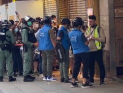 香港警方6月28日下午在旺角登打士街展开大围捕,传媒联络队人员检查采访期间被封锁线围困记者的证件才放行。 (美国之音/汤惠芸)