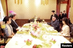 中国国家主席习近平和夫人彭丽媛,朝鲜国务委员会委员长金正恩和夫人李雪主在北京会面(2018年3月28日发布的照片,具体日期不详)。