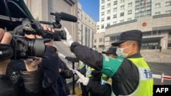 一名警察挡住记者的镜头阻止拍摄审讯公民记者张展的上海浦东新区法院外景。(2021年12月28日)