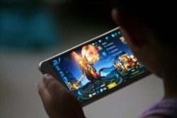 资料照:中国山东省一名孩子在家中玩腾讯推出的游戏。