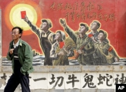 一人走过银川郊外一家电影制片厂的文革宣传画。邓小平否定文革,他在文革中曾被名列牛鬼蛇神(资料照片)