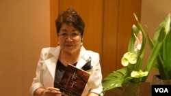 远藤誉接受美国之音采访时,展示早已被译成中文的《卡子》(美国之音歌篮拍摄)