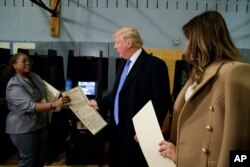 川普夫妇把自己的选票交给选举工作者(2016年11月8日)
