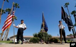 美国战俘、作战失踪军人组织的成员在凤凰城停放美国会参议员麦凯恩灵柩的殡仪馆前站岗。(2018年8月26日)