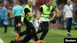 闯入决赛球场稿行为艺术的俄罗斯女性主义朋克乐队Pussy Riot (暴动小猫)成员被拖走(2018年7月15日)