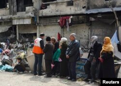 Người tị nạn đợi phân phát cứu trợ tại trại tị nạn của người Palestine tại Damascus, Syria.