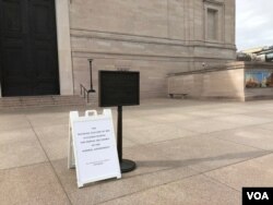 华盛顿史密森尼国家美术馆大门紧闭,门口告示牌向游人解释博物馆因联邦政府关闭而关门。(2019年1月23日)