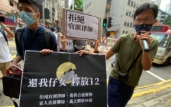 9月30日任期届满后离任的民主派立法会议员朱凯迪（右），在任期最后一日与本土派社运人士邹家成（左）陪同多名被关押盐田看守所的港人家属，到中联办外请愿，重申拒绝官派律师等4大诉求 （美国之音汤惠芸）