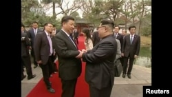 中国国家主席习近平在北京钓鱼台国宾馆的养源斋前面同朝鲜国务委员会委员长金正恩握手(2018年3月28日发布的视频的截图)