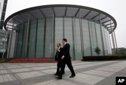 英国财政大臣乔治•奥斯本与华为公司CEO和创始人任正非在深圳参观华为总部会晤之前一道走过一座会议厅。(2013年10月16日)