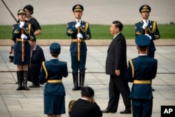 中国国家主席习近平在北京天安门广场举行的仪式上走向人民英雄纪念碑。习近平等中国领导人在烈士纪念日送了花篮(2017年9月30日)