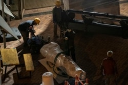 在香港大学，工人移除丹麦艺术家高志活纪念1989年天安门镇压事件受害者的雕塑“国殇之柱”的一部分，搬往一座集装箱。(2021年12月23日)